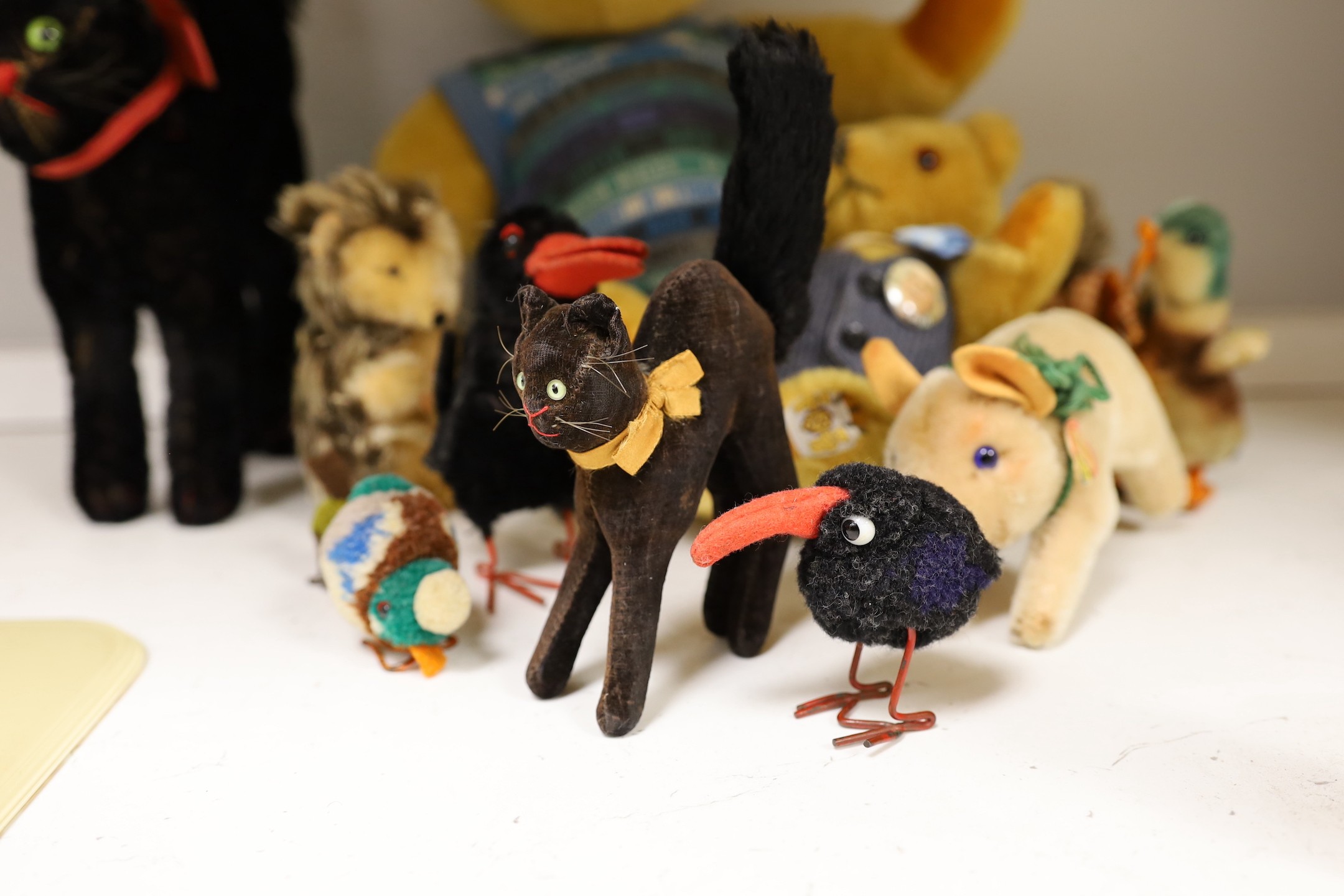 A collection of toys - a small black cat, a large black cat, a small pig, a hedgehog, a Macki hedgehog, two crows, a duck, two small birds with wire feet and two Peter Bull bears with pedigree certs. (12)